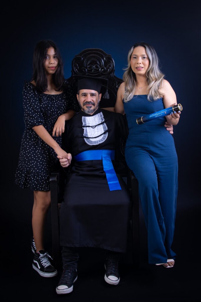 Formando de Análise e Desenvolvimento de Sistemas na Cadeira Colonial Luiz XV com duas pessoas da família, uma segurando o canudo