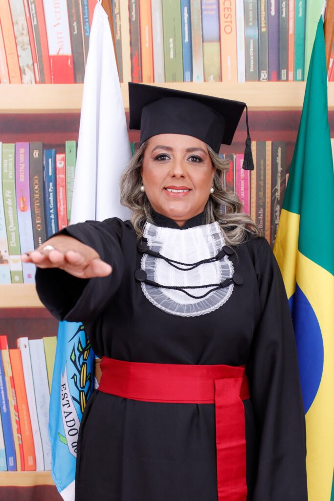 Formanda de Ciências Contábeis fazendo o juramento entre as bandeiras do Brasil e do Rio de Janeiro, no cenário de biblioteca