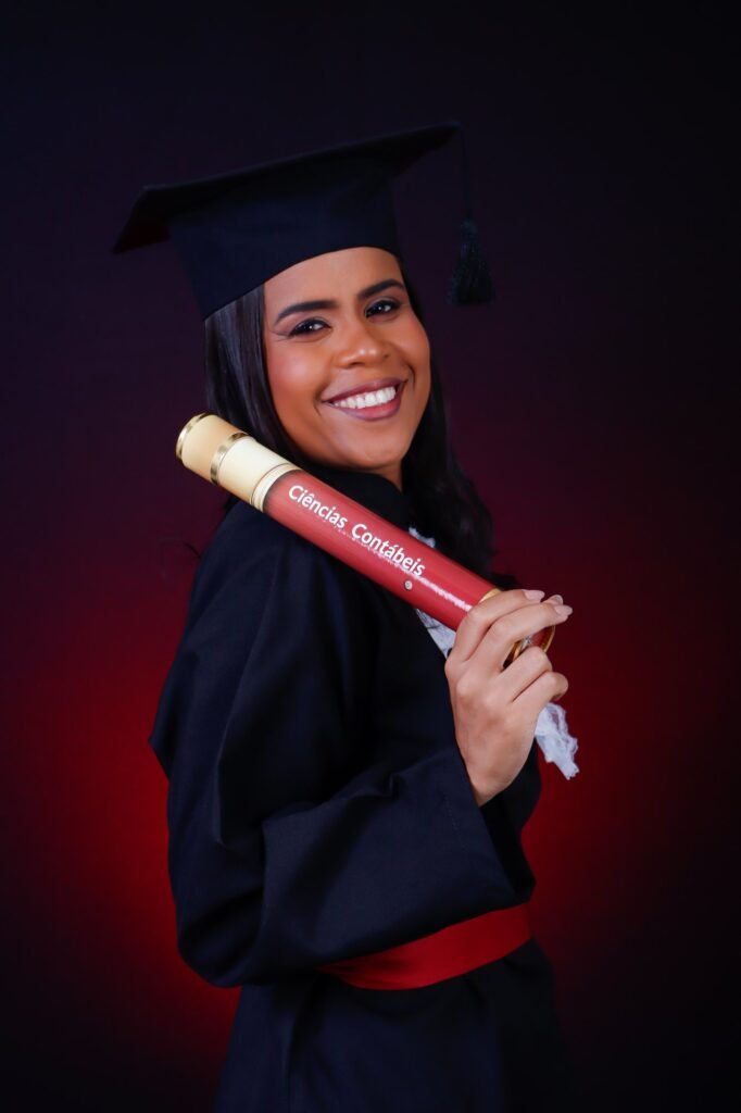 Formanda de Ciências Contábeis com o canudo do curso apoiado no ombro, sorrindo, no estúdio do Z7 Studio