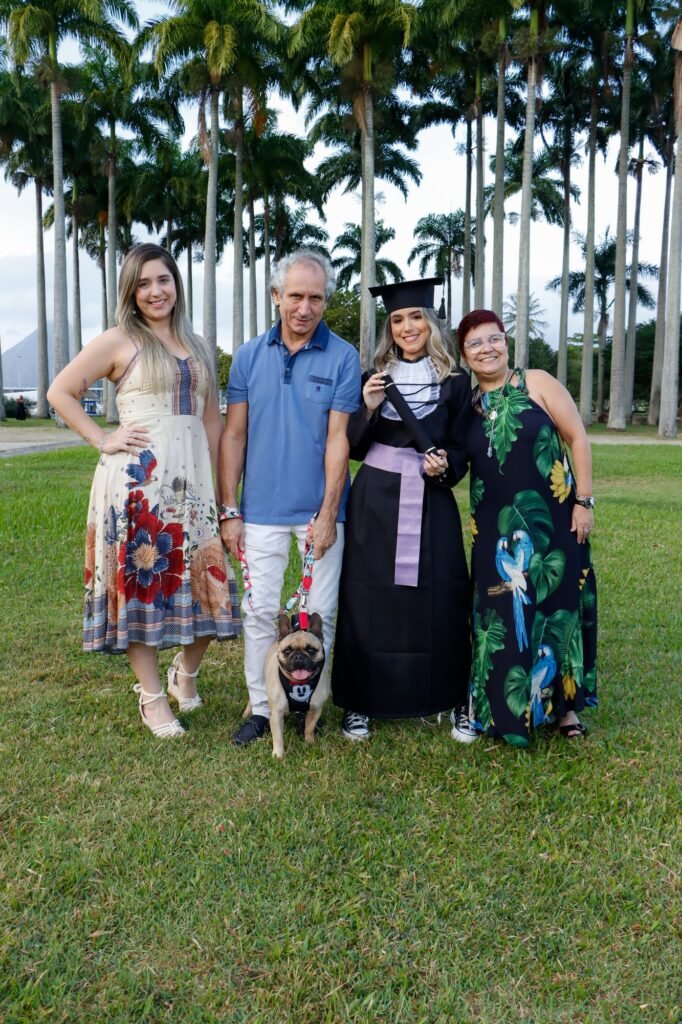 Formanda de Recursos Humanos com a família e o cachorro entre as palmeiras do MAM
