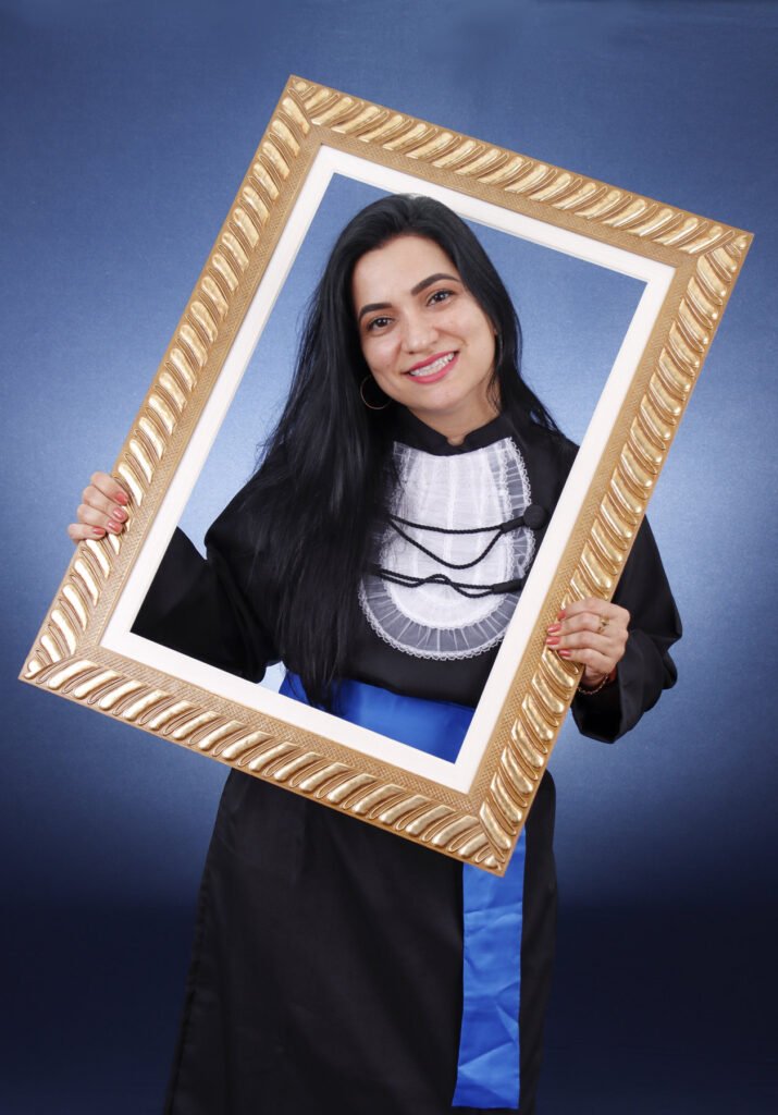 Formanda de Fotografia sorrindo com uma moldura dourada nas mãos