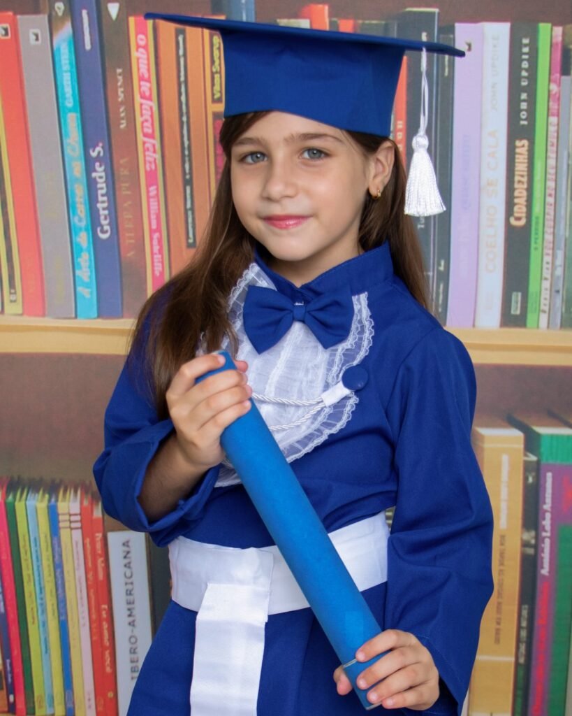 Criança de beca azul e capelo no ensaio de formatura infantil no estúdio do Z7 Studio