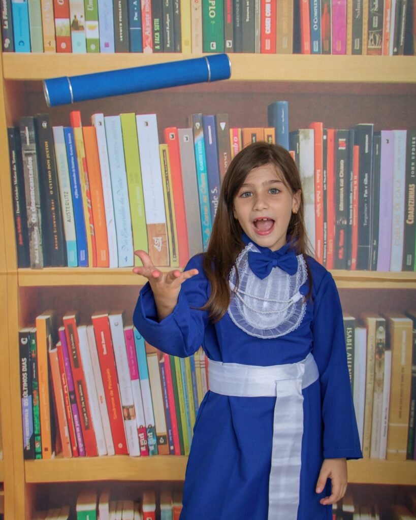 Criança de beca azul e capelo no ensaio de formatura infantil no estúdio do Z7 Studio