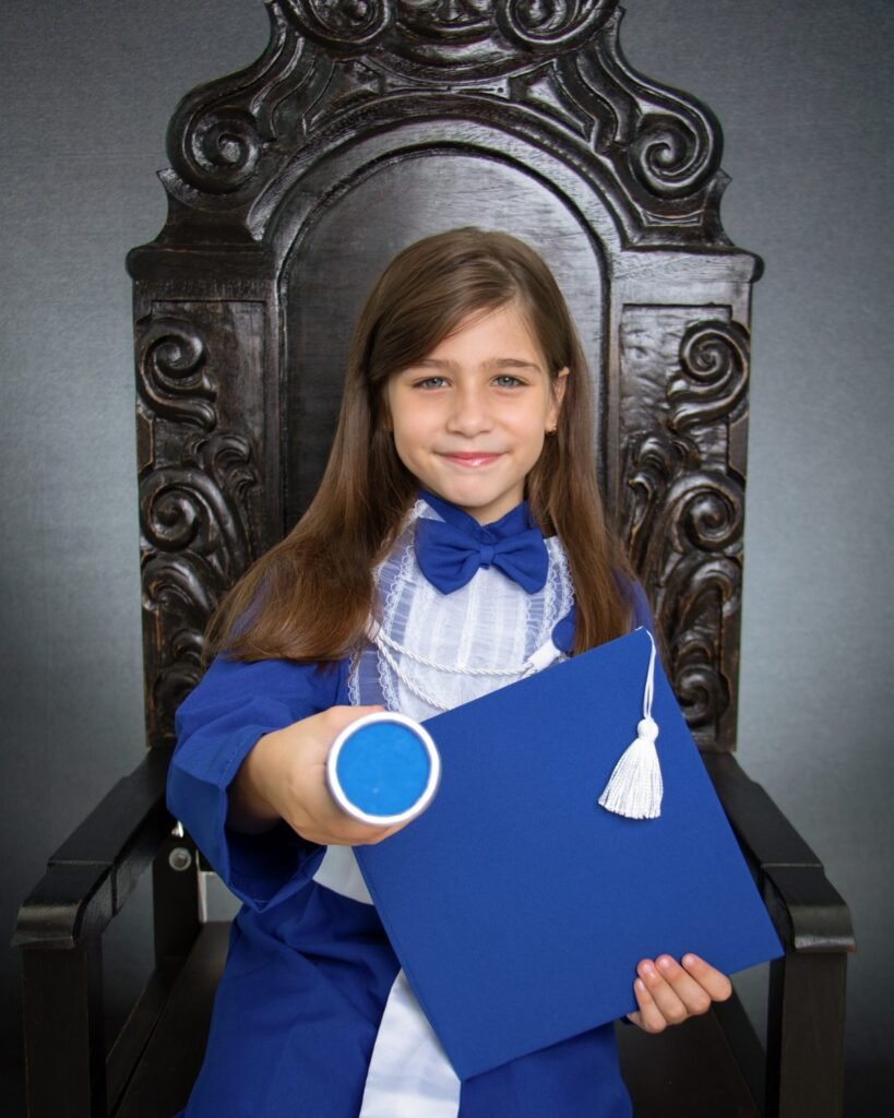 Criança de beca azul e capelo no ensaio de formatura infantil no estúdio do Z7 Studio