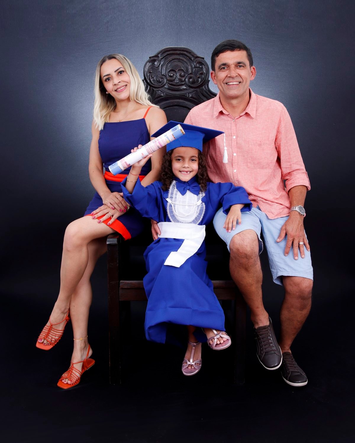 Pais e filha de beca azul na Cadeira Colonial Luiz XV, com o canudo erguido