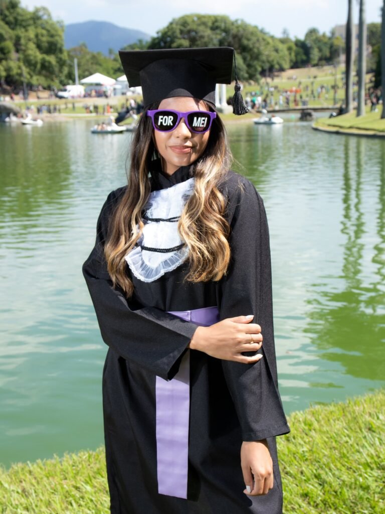 Formanda de Química do IFRJ de faixa lilás com óculos roxos escrito FORMEI, à beira do lago da Quinta da Boa Vista