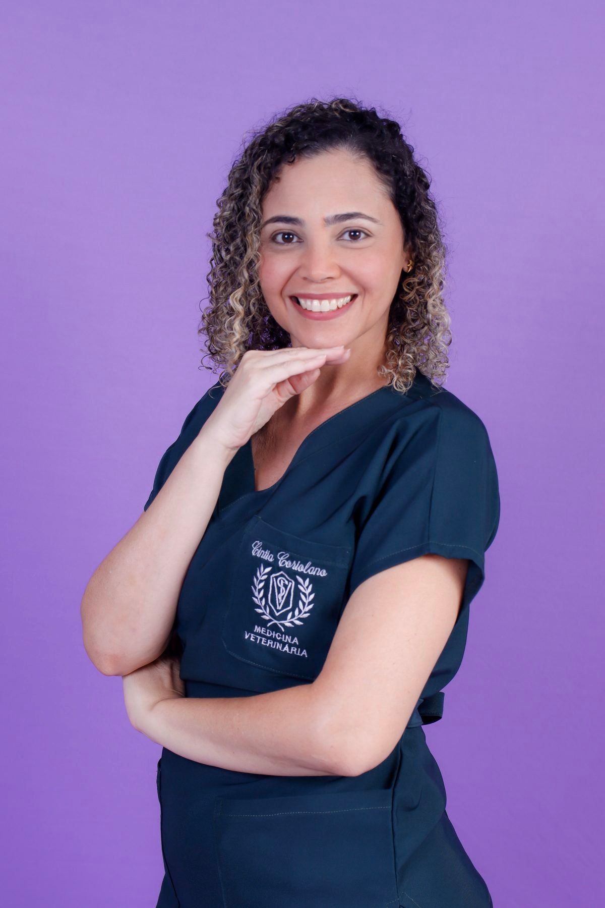 Veterinária de pijama cirúrgico com a mão no queixo no fundo lilás