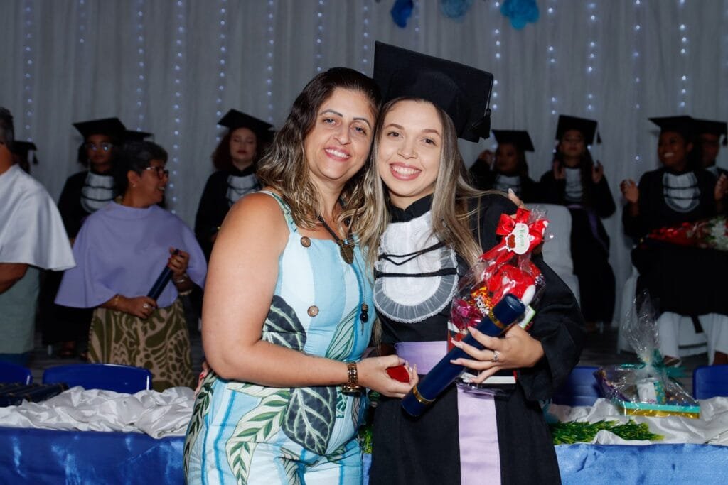 Formanda abraçada a uma convidada depois de receber o diploma