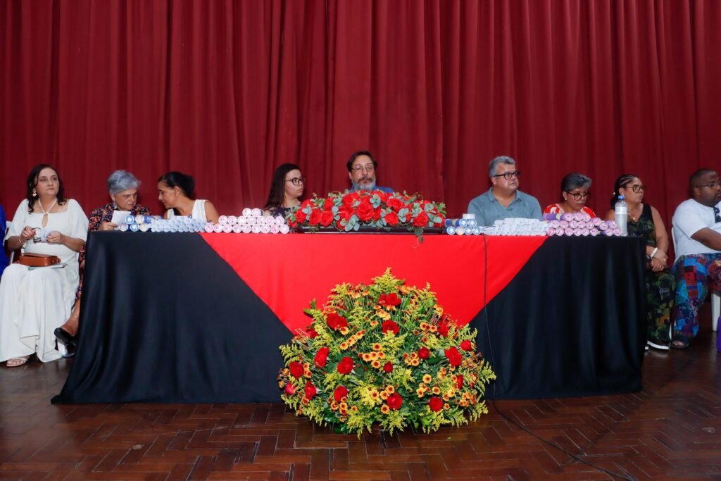 Canudos enfileirados sobre a mesa de honra com arranjo de flores